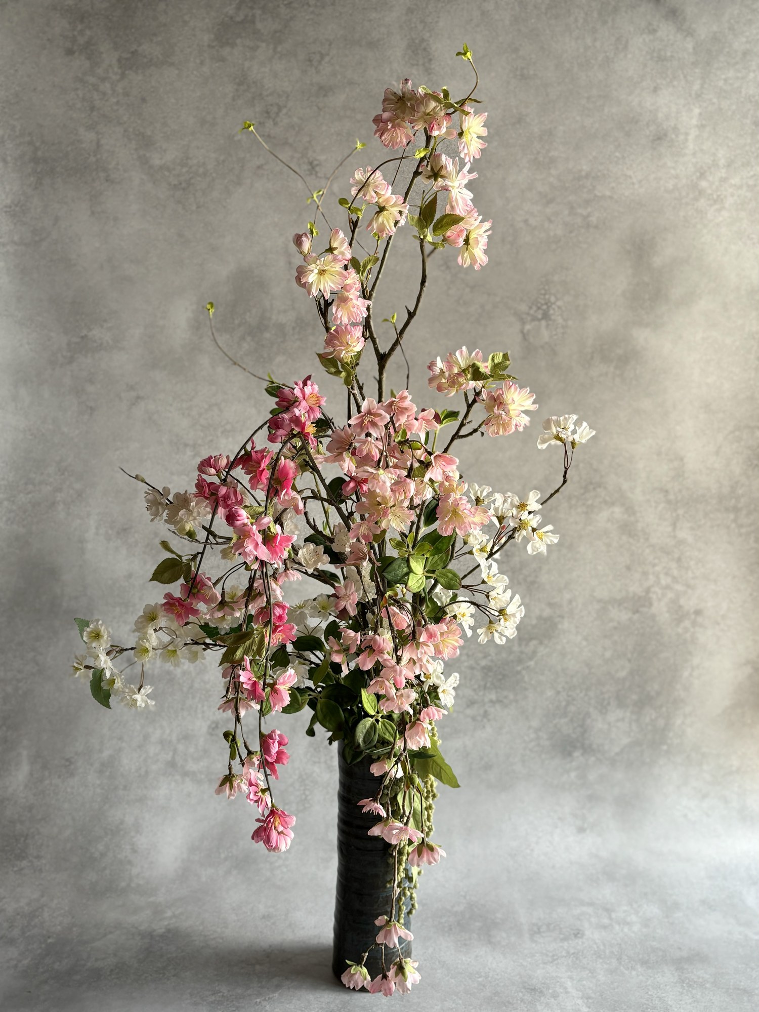 枝ものとピンクの花を使ったフラワーアレンジメント